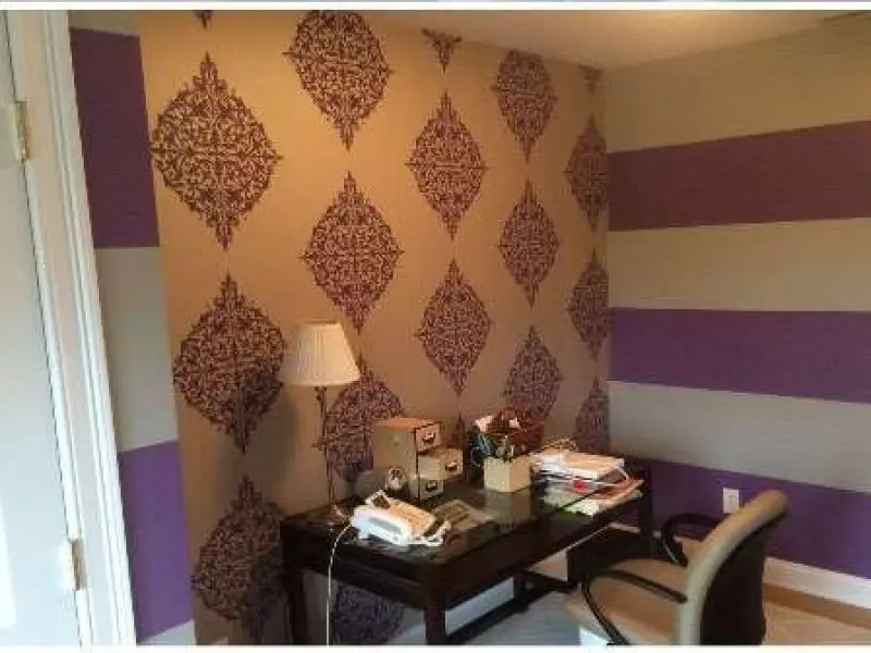 Another photo of a home office. Liberty Painting updated the wall coverings using purple and white pattern wallpaper.