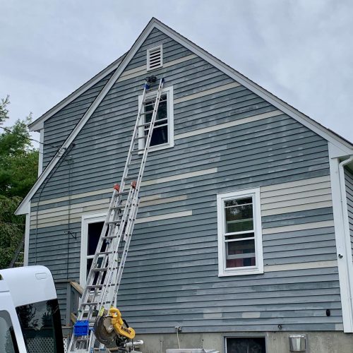 A photo taken during a project updating the clapboards on a house.