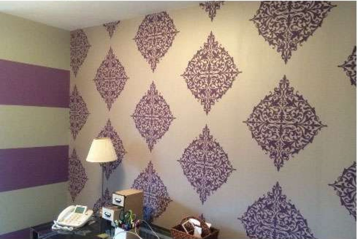 A photo of a home office. Liberty Painting updated the wall coverings using purple and white pattern wallpaper.