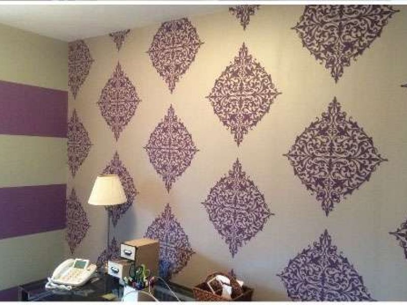 A photo of a home office. Liberty Painting updated the wall coverings using purple and white pattern wallpaper.