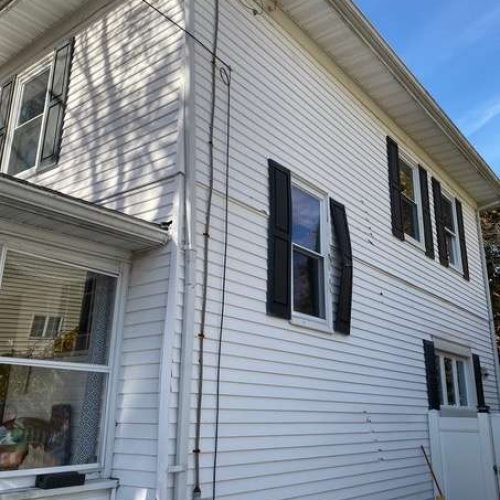 A before photo of a house in Canton, MA which needed new siding.