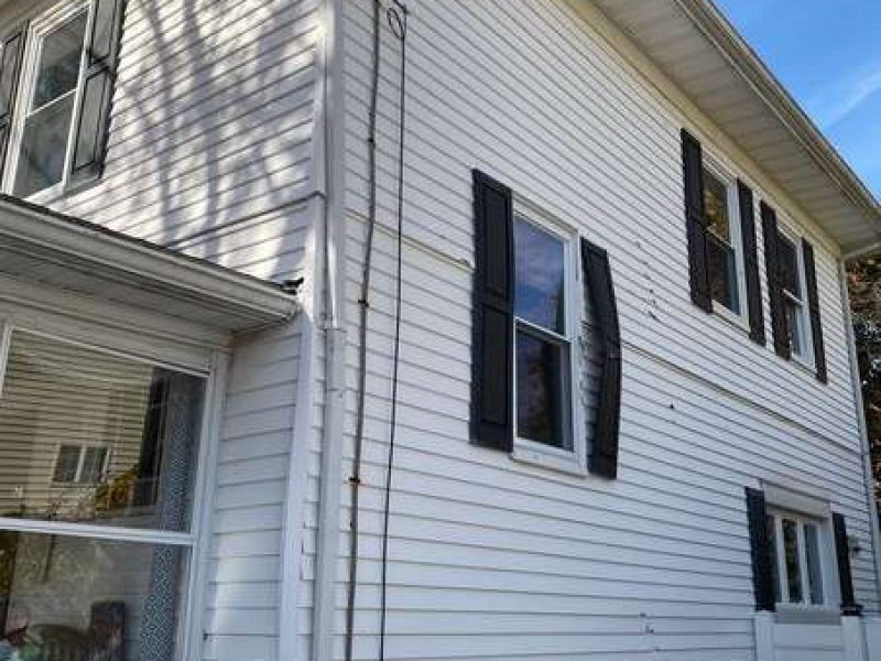 A before photo of a house in Canton, MA which needed new siding.