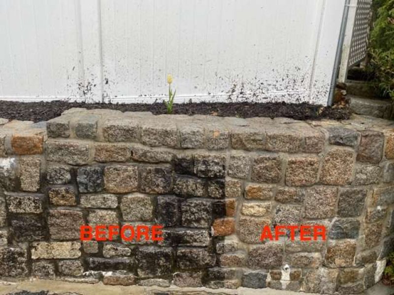 Before and after photo showing the difference on a garden stone wall with Liberty Painting's expert power-washing service. One side is caked in dirt while the other looks squeaky clean.